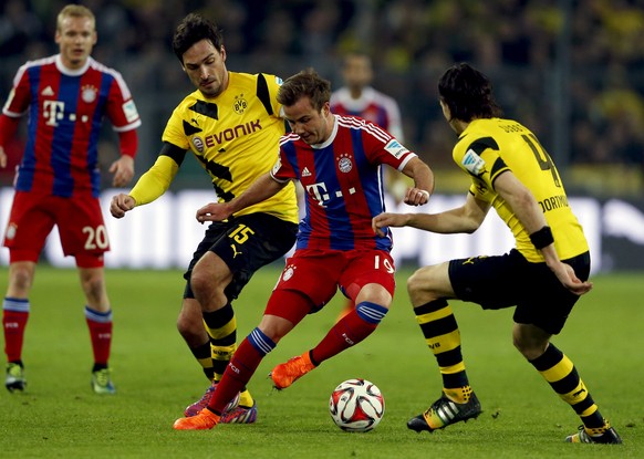 Mario Goetze of Bayern Munich is sandwiched by Borussia Dortmund Mats Hummels (L) and Neven Subotic during their German first division Bundesliga soccer match in Dortmund April 4, 2015. REUTERS/Wolfga ...