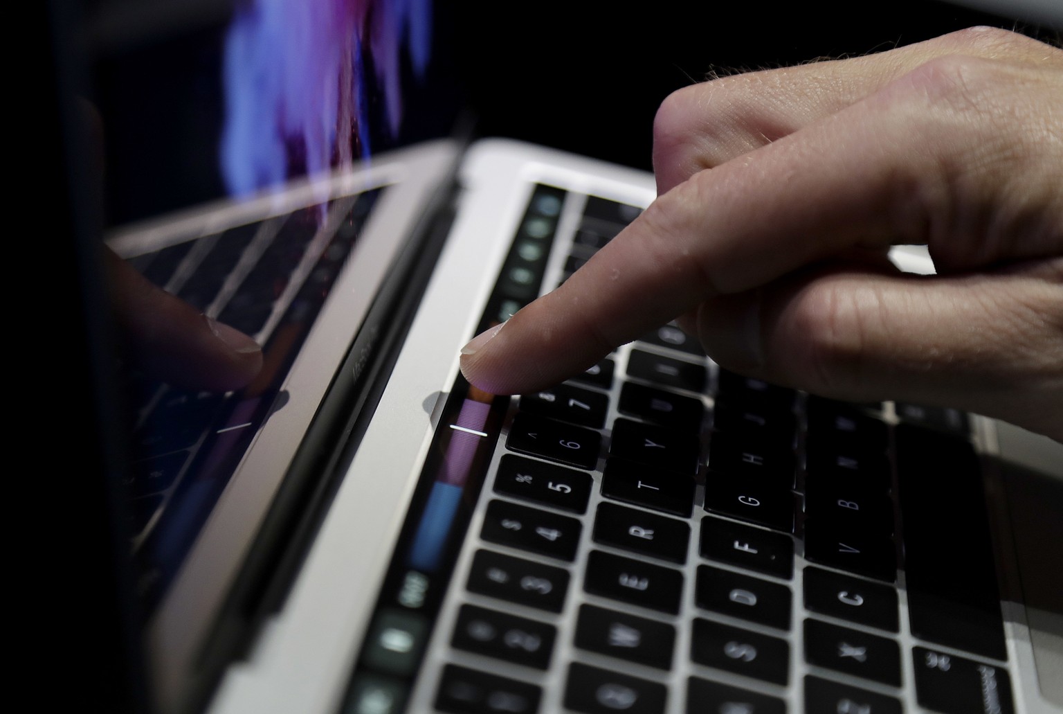 A guest looks at the Touch Bar on a MacBook computer shown in a demo room following the announcement of new products at Apple headquarters Thursday, Oct. 27, 2016, in Cupertino, Calif. (AP Photo/Marci ...