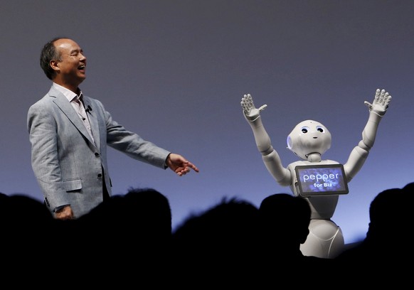 SoftBank Group Corp. Chairman and CEO Masayoshi Son reacts as SoftBank&#039;s human-like robots named &quot;Pepper&quot; performs during the SoftBank World 2015 event in Tokyo, Japan, in this July 30, ...
