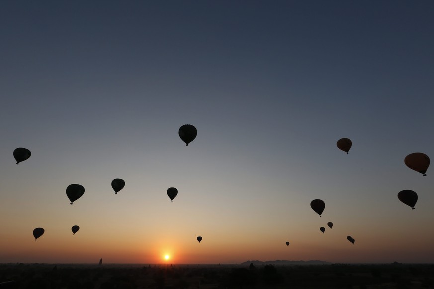 epa05748418 Balloons carrying visitors fly at sunrise over old temples of the ancient temple city of Bagan, Mandalay Region, Myanmar, 25 January 2017. EPA/HEIN HTET