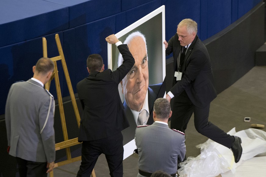 European Parliament employees set up a giant portrait of former German Chancellor Helmut Kohl before an European ceremony in Strasbourg, eastern France, Saturday Juny 1, 2017. Germany will later bid f ...