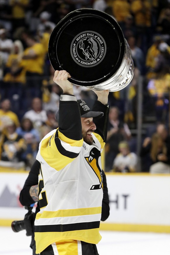 Pittsburgh Penguins defenseman Mark Streit, of Switzerland, celebrates with the Stanley Cup after the Penguins defeated the Nashville Predators 2-0 in Game 6 of the NHL hockey Stanley Cup Finals Sunda ...