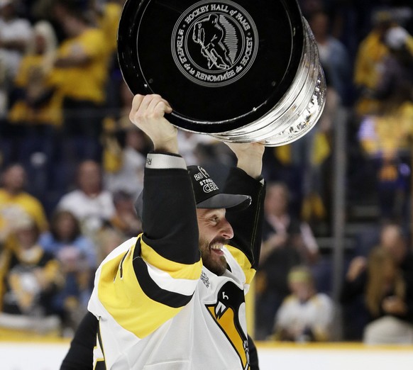 Pittsburgh Penguins defenseman Mark Streit, of Switzerland, celebrates with the Stanley Cup after the Penguins defeated the Nashville Predators 2-0 in Game 6 of the NHL hockey Stanley Cup Finals Sunda ...