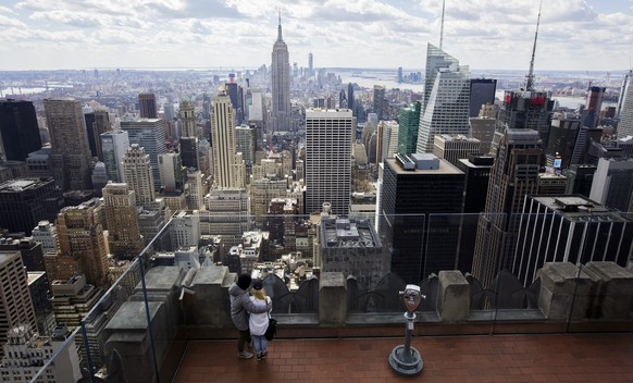 epa05219003 Two people look out on the skyline from the observation deck on the Top of the Rock at Rockefeller Center in New York, New York, USA, 18 March 2016. 30 Rockerfeller Center has 70 floors an ...