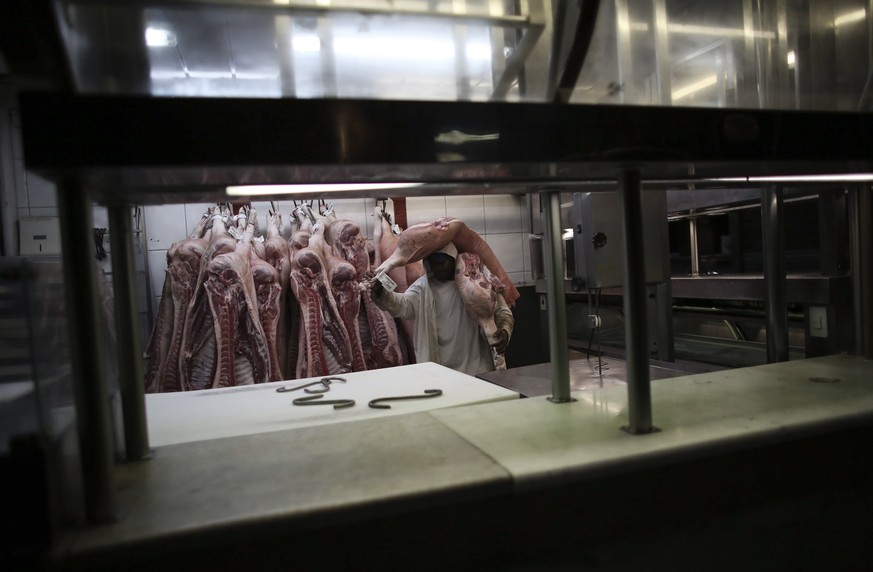 A worker carries meat inside a stall before selling meat at the Municipal Market in Sao Paulo October 10, 2014. Consumer price rose a faster-than-expected 6.75 percent in the 12 months through Septemb ...