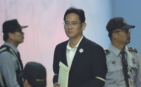 Lee Jae-yong, center, vice chairman of Samsung Electronics, arrives at the Seoul Central District Court for a hearing in Seoul, South Korea, Thursday, Oct. 12, 2017. Prosecutors are citing a past ruli ...