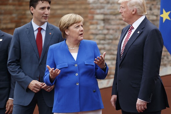 German Chancellor Angela Merkel, center, talks with Canadian Prime Minister Justin Trudeau, left, and President Donald Trump during a family photo with G7 leaders at the Ancient Greek Theater of Taorm ...