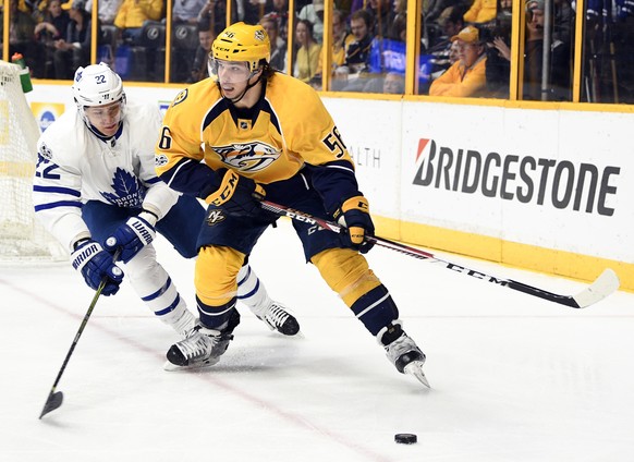 Mar 30, 2017; Nashville, TN, USA; Nashville Predators left wing Kevin Fiala (56) looks to pass the puck as he is defended by Toronto Maple Leafs defenseman Nikita Zaitsev (22) during the first period  ...