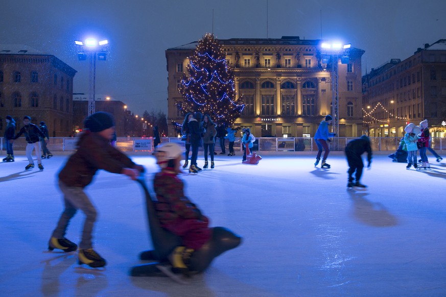 Kinder und Jugendliche vergnuegen sich auf dem Eisplatz auf dem Bundesplatz, am Samstag, 27. Dezember 2014 in Bern. (KEYSTONE/Peter Klaunzer)