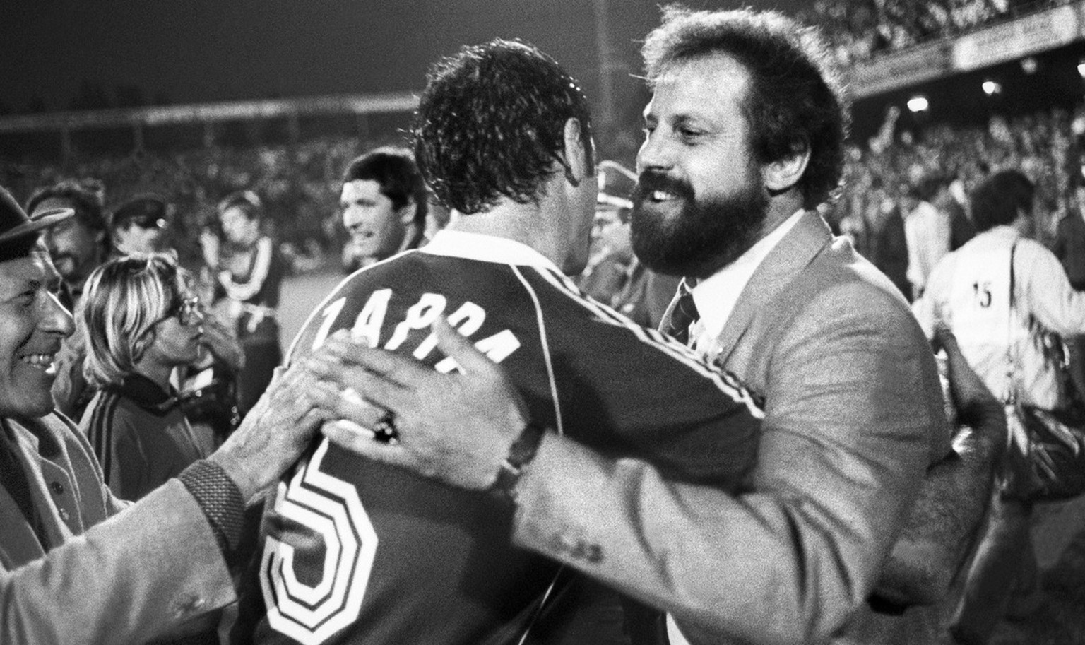Paul Wolfisberg, Coach der Schweizer Fussballnationalmannschaft, umarmt Gianpietro Zappa nach dem 2:1 Sieg in der WM-Qualifikation gegen England am 30. Mai 1981 in Basel. (KEYSTONE/Str)