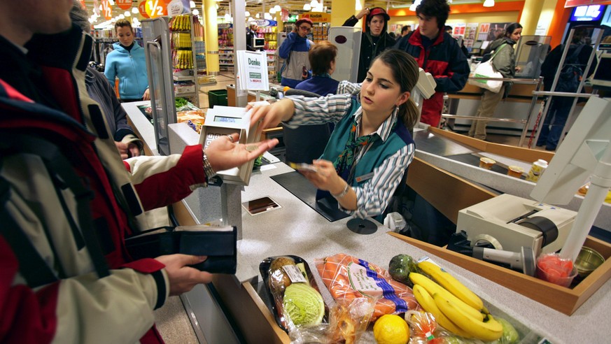 Eine Mann bezahlt am 20. Januar 2005 an einer Kasse im Migros Limmatplatz in Zuerich seine Einkaeufe. Migros zaehlt zu den groessten Anbietern in der Schweiz. Das Verkaufsnetz umfasst insgesamt 587 St ...