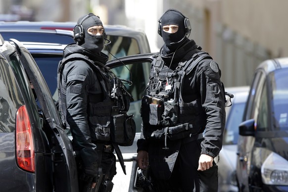 Hooded police officers patrol outside a building during searches in Marseille, southern France, Tuesday, April 18, 2017. Security concerns shook France&#039;s presidential campaign Tuesday as authorit ...