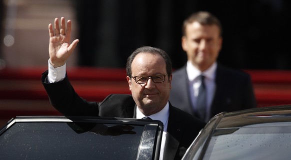 epa05963091 Outgoing French President Francois Hollande (L) waves to the crowd as new French President Emmanuel Macron (R) looks on during a handover ceremony at the Elysee Palace, in Paris, France, 1 ...