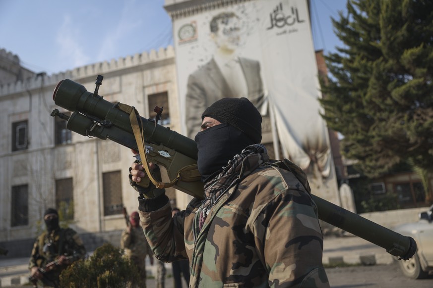 Nachrichten Linkding A Syrian opposition fighter holds a rocket launcher in front of the provincial government office, where an image of Syrian President Bashar Assad is riddled with bullets on the facade, in the aftermat ...