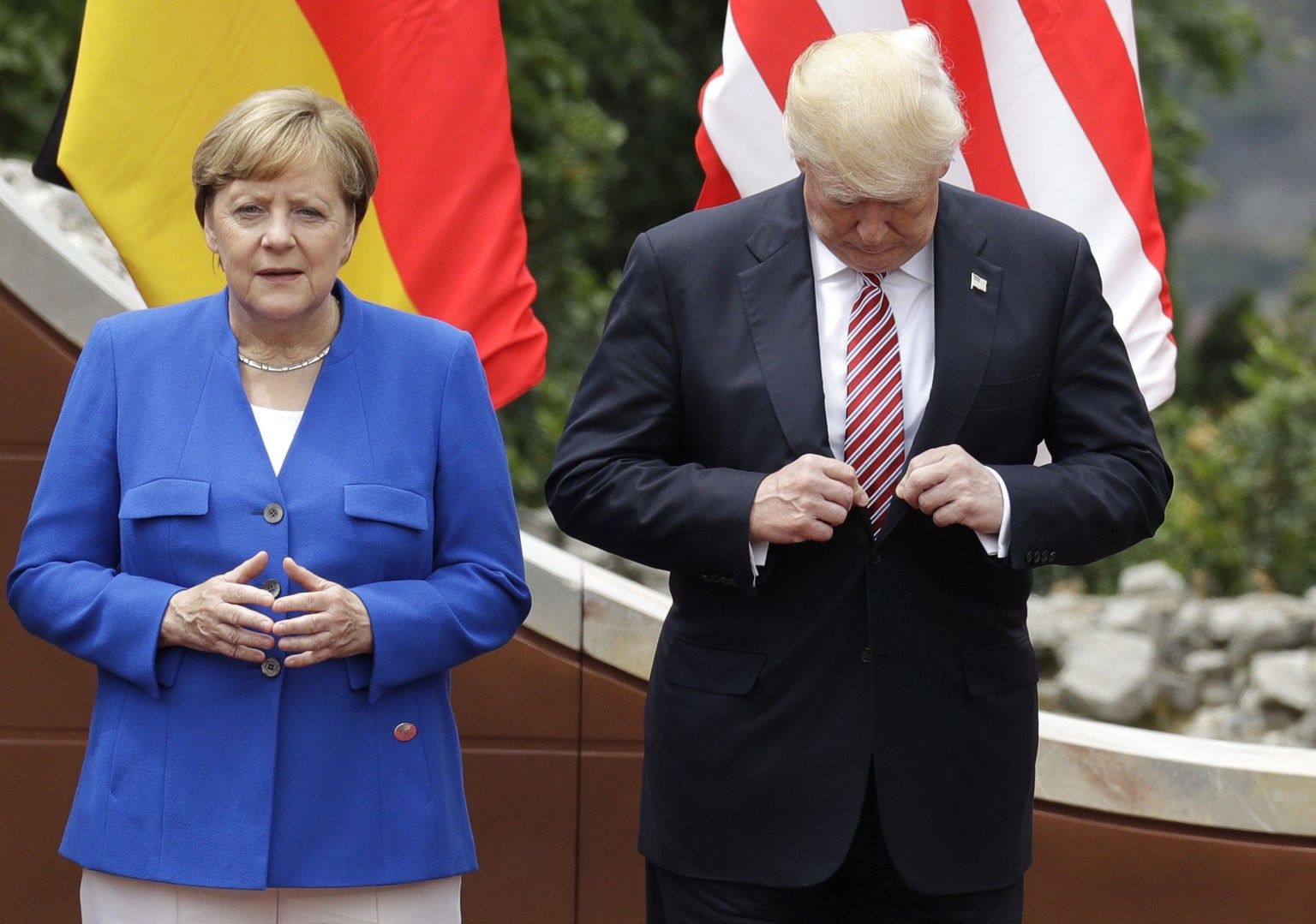 U.S. President Donald Trump, right, adjusts his jacket as he stands with German Chancellor Angela Merkel prior to a group photo during a G7 Summit in the Ancient Theatre of Taormina ( 3rd century BC)  ...