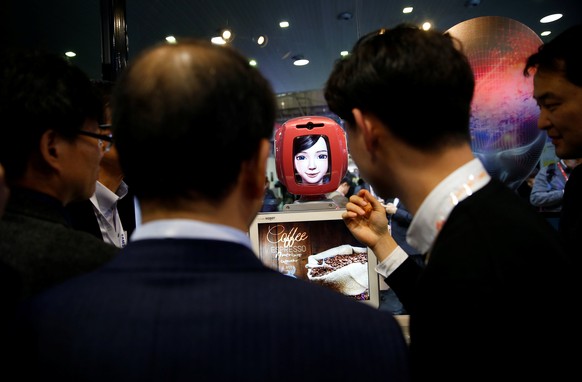 Attendees interact with Commerce Bot, a robot that provides customer service with artificial intelligence technology and voice recognition, at SK telecom&#039;s stand at the Mobile World Congress in B ...