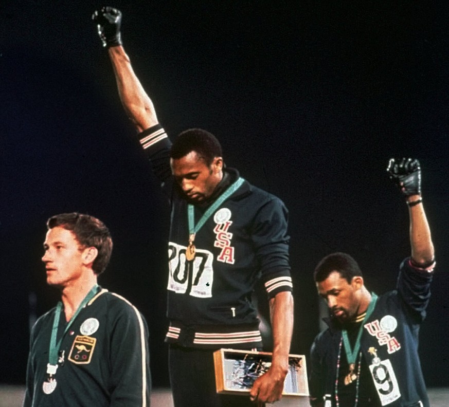Eines der berühmtesten Bilder in der Geschichte des Sports: An der Siegerehrung über 200 Meter in Mexiko 1968 protestieren die beiden Amerikaner Tommie Smith (Mitte) und John Carlos gegen die Unterdrü ...