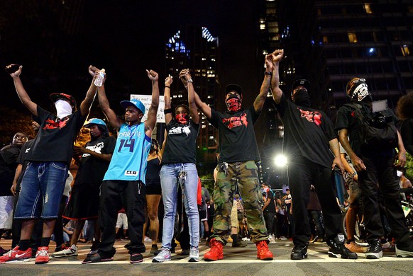 Protesters raise their arms during a march in Charlotte, N.C. on Thursday, Sept. 22, 2016. The curfew has ended for Friday in Charlotte following a night of mostly peaceful protests of the shooting of ...