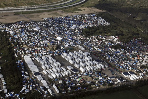 FILE - In this Monday, Oct. 17, 2016 file photo showing an aerial view of a makeshift migrant camp near Calais, France. A French court has ruled against creating a new center for migrants in the weste ...