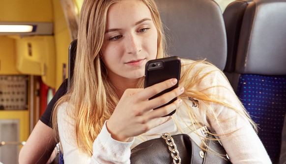 Adolescents chat as one of them uses her phone while commuting in the city train between Zurich and Zug, Switzerland, on June 16, 2015. (KEYSTONE/Christof Schuerpf)

Jugendliche unterhalten sich waehr ...