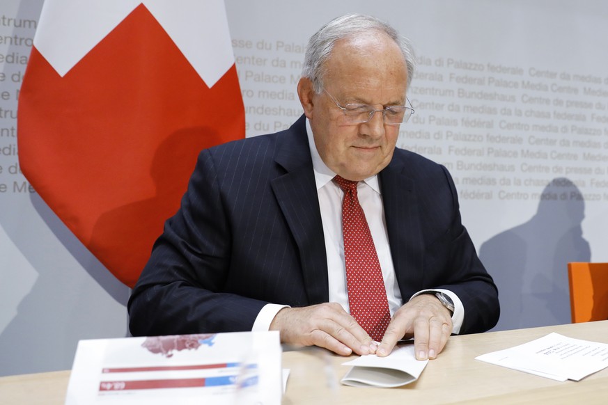   Federal councilor Johann Schneider-Ammann folds his documents , is the end of a media conference on the Swiss Federal Elections, on Sunday, 23 September 2018 in Bern. (KEYSTONE / Peter Klaunzer) 