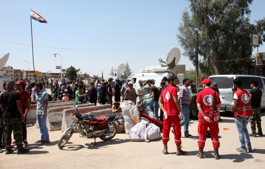epa05530158 Volunteers of the Syrian Arab Red Crescent assist evacuees from the rebel-held al-Moadhamiyeh city in the countryside of Damascus, Syria, 08 September 2016. According to media reports, abo ...
