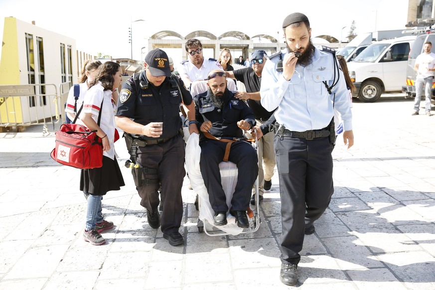 epa06086241 An Israeli policeman is evacuated from the Temple Mount compound in Jerusalem&#039;s Old City, 14 July 2017. According to police sources, three Palestinian attackers opened fire on police  ...