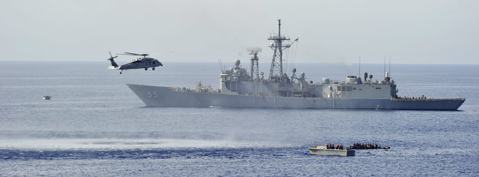 epa04244200 A handout image released by the US Navy Media Content Service (NMCS) on 07 June 2014 shows the guided-missile frigate USS Elrod (FFG 55) assisting in the rescue of distressed persons in th ...
