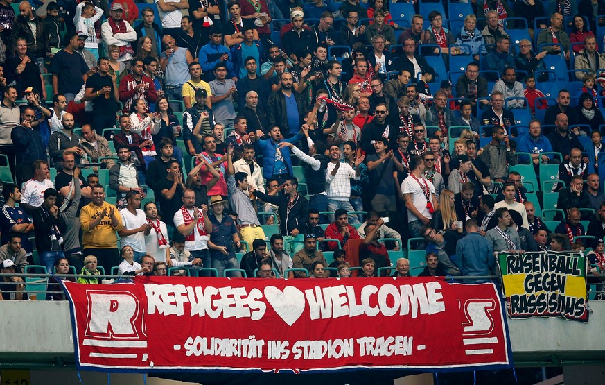 LEIPZIG, GERMANY - SEPTEMBER 11: Invited refugees celebrate with fans of Leipzig during the Second Bundesliga match between RB Leipzig and SC Paderborn at Red Bull Arena on September 11, 2015 in Leipz ...