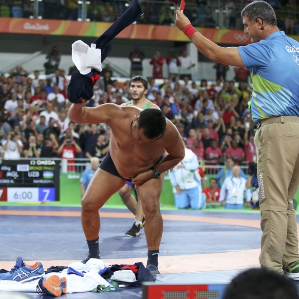 2016 Rio Olympics - Wrestling - Final - Men&#039;s Freestyle 65 kg Bronze - Carioca Arena 2 - Rio de Janeiro, Brazil - 21/08/2016. The coach of Mandakhnaran Ganzorig (MGL) of Mongolia takes off his cl ...