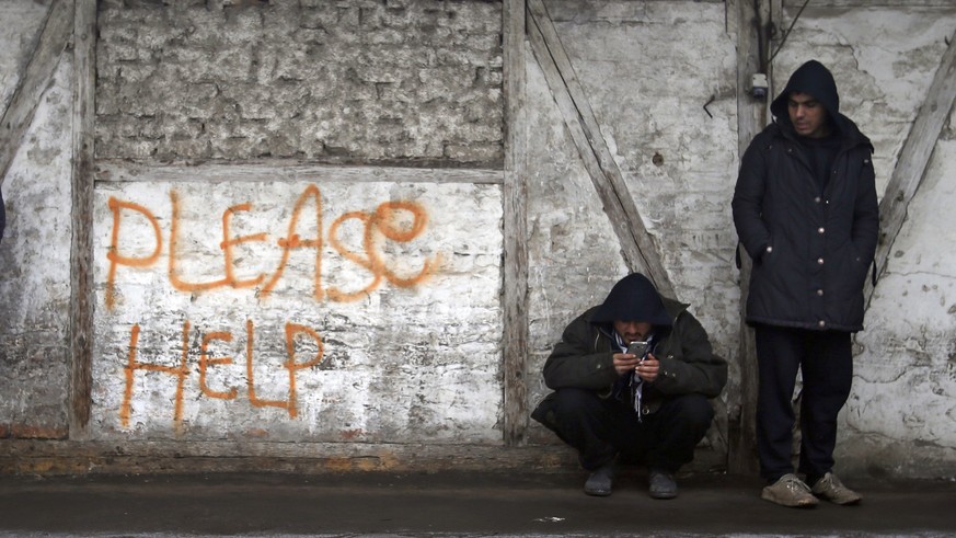 Migrants rest in front of an abandoned warehouse in Belgrade, Serbia, Wednesday, Jan. 25, 2017. Hundreds of migrants have been sleeping rough in freezing conditions in downtown Belgrade looking for wa ...