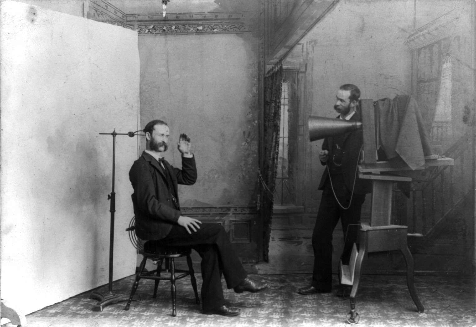 Berlin, 1893: Ein Fotograf fotografiert sich selbst, eine Satire auf die frühe Fotografiepraxis, die mit ellenlangen Belichtungszeiten kämpfen musste.