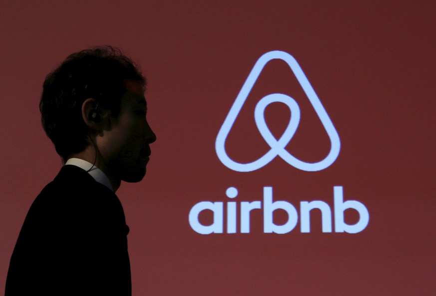 A man walks past a logo of Airbnb after a news conference in Tokyo, Japan, November 26, 2015. REUTERS/Yuya Shino/File Photo