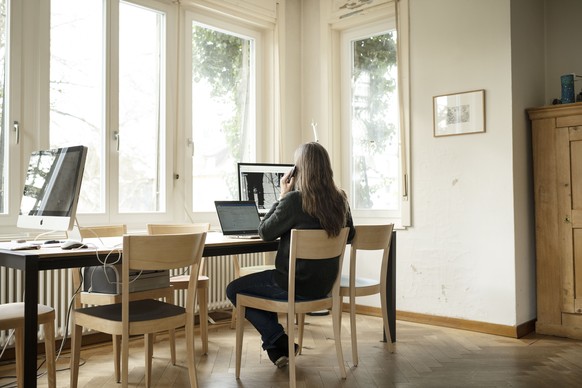 AVIS --- ZUM THEMA HOMEOFFICE STELLEN WIR IHNEN FOLGENDES BILD ZUR VERFUEGUNG. WEITERE BILDER FINDEN SIE AUF visual.keystone-sda.ch --- Eine Frau telefoniert an ihrem Arbeitsplatz im Homeoffice, fotog ...