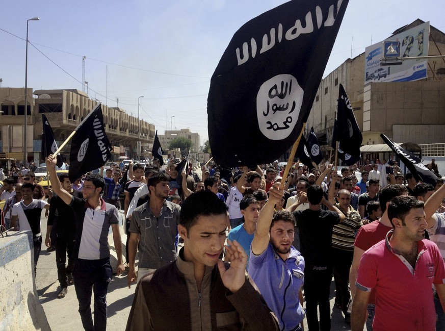 FILE - In this June 16, 2014 file photo, demonstrators chant pro-Islamic State group, slogans as they carry the group&#039;s flags in front of the provincial government headquarters in Mosul, 225 mile ...