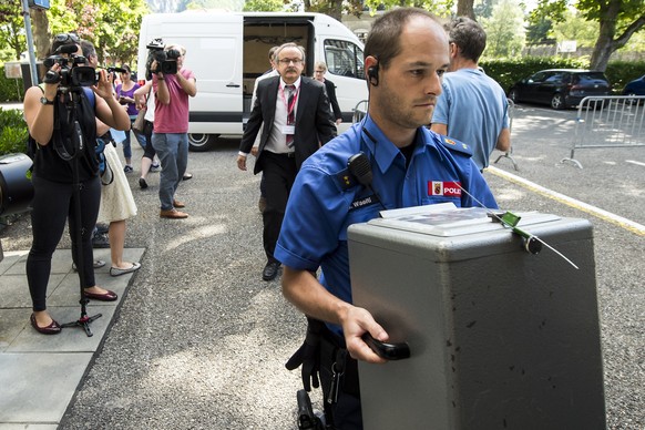 Un policier bernois transporte une urne de vote par correspondance dans le bureau de vote installe a la Societ&#039;halle ce dimanche 18 juin 2017 a Moutier. Le 18 juin, les citoyens de Moutier doiven ...