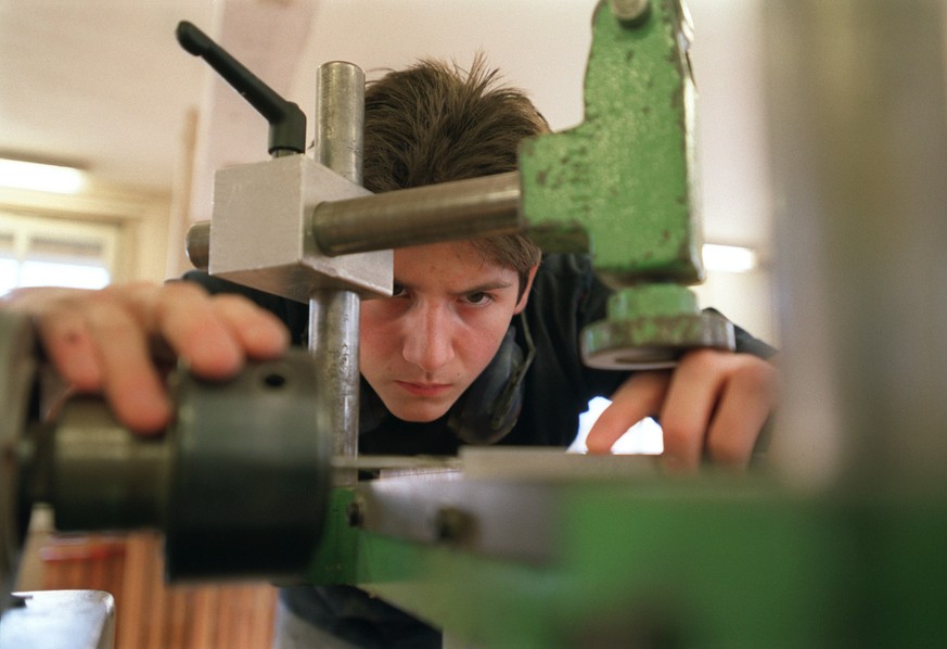 Ein Lehrling bei der Arbeit an der Maschine im Unterricht an der Abteilung Lehrwerkstaette fuer Moebelschreiner an der baugewerblichen Berufsschule Zuerich, aufgenommen am 4. Maerz 2003. (KEYSTONE/Gae ...