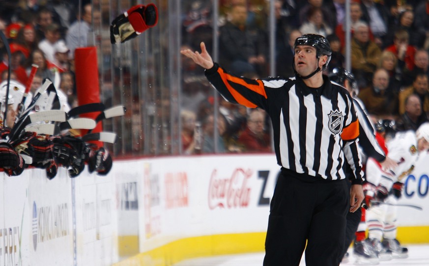 Auger wirft als NHL-Schiedsrichter der Spielerbank der Ottawa Senators einen auf dem Eis verlorenen Handschuh zu.