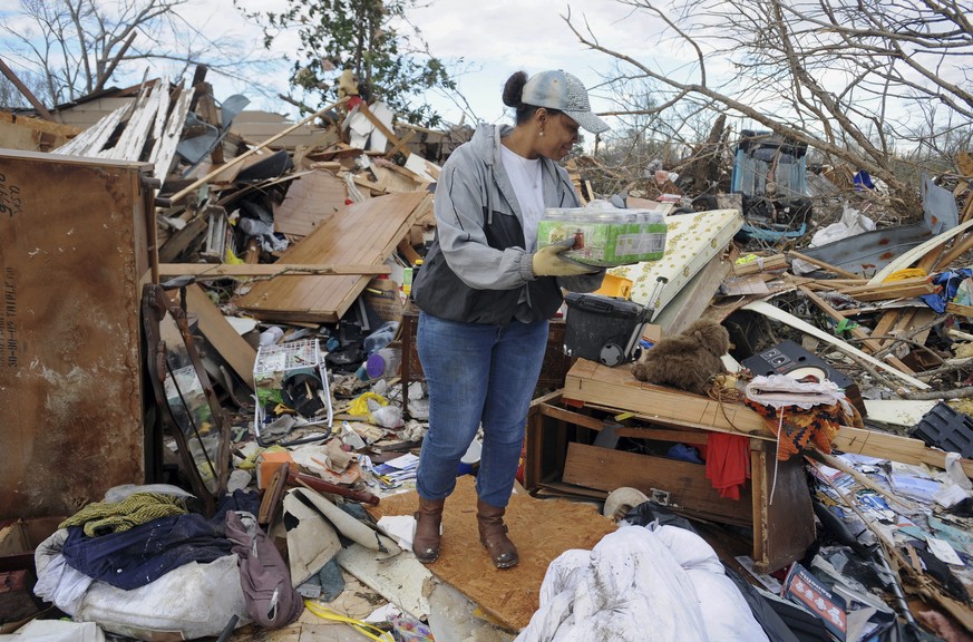 A volunteer helps salvage a Hall Avenue resident&#039;s personal belongings as cleanup continued in the Hattiesburg, Miss., neighborhoods that were destroyed from Saturday&#039;s twister Sunday, Jan.  ...