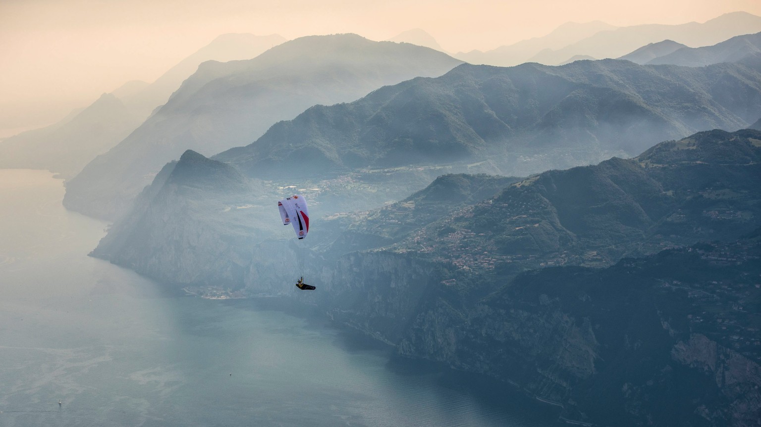 epa06073926 A handout photo made available by Global Newsroom on 07 July 2017 of Christian Maurer (SUI1) flying during the Red Bull X-Alps above Lake Garda, Italy, 06 July 2017. At this extreme advent ...