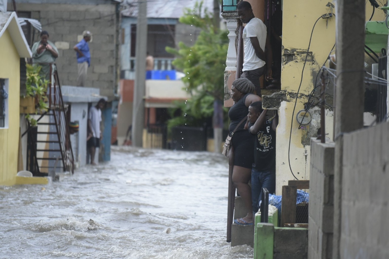 epa06190107 People watch flooded water in a street in Santiago de los Caballeros, Dominican Republic, Dominican Republic, 07 September 2017. More than 5,500 people have been evacuated in the Dominican ...