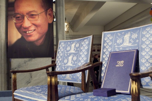 epa02488738 The Nobel diploma and Nobel medal on the empty chair during the ceremony to honor this years Nobel Peace Prize winner, jailed Chinese dissident Liu Xiaobo (portrait pictured on wall) in Os ...