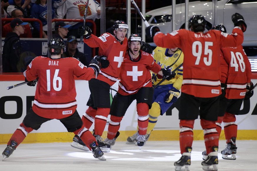 Switzerland&#039;s Roman Josi, 2nd left, celebrates his goal with teammates Raphael Diaz, left, Morris Trachsler, 3rd left, Julian Walker, 2nd right, and Matthias Bieber, right, after scored the 1:0,  ...