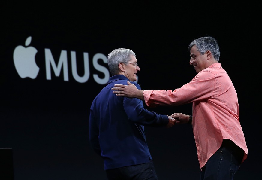 Zufriedene Apple-Manager: Eddy Cue (r.) übergibt Tim Cook die Fernsteuerung.