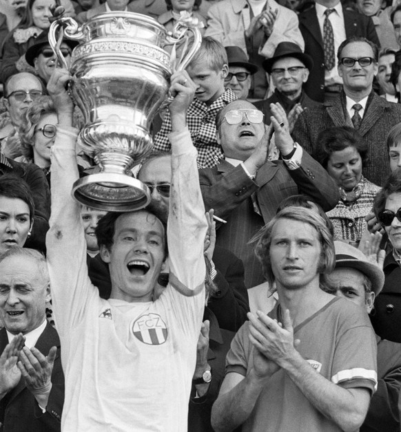 Koebi Kuhn, Captain des FCZ, freut sich mit dem Pokal ueber den Sieg im Cupfinal gegen Basel. FCB-Captain Karl Odermatt, rechts, applaudiert kollegial. Der FC Zuerich gewinnt am 23. April 1973 den Cup ...