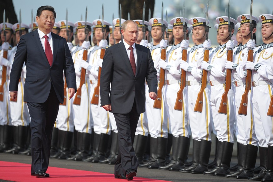 Russia&#039;s President Vladimir Putin, centre, and China&#039;s President Xi Jinping left, walk to open joint naval exercises in Shanghai, China, Tuesday, May 20, 2014. (AP Photo/RIA Novosti, Alexei  ...