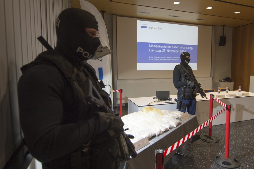 Zwei Polizeibeamte stehen neben den beschlagnamten 55 Kilogramm Heroin, am Dienstag, 25. November 2014, in Zug. Die Zuger Strafverfolgungsbehoerden zerschlagen, nach einem Tip aus Hamburg, DE, einen D ...