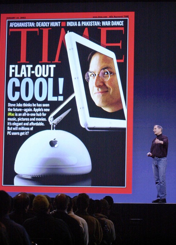 Apple Computers Inc. chief executive Steve Jobs stands next to a copy of this week&#039;s Time Magazine cover as he introduces the new flat screen iMac at Macworld in San Francisco, Monday, Jan. 7, 20 ...