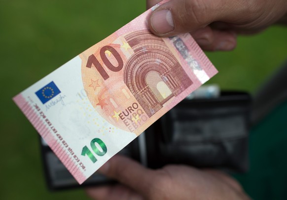 epa04413113 A person holds a 10 euro note in Bonn, Germany, 23 September 2014. The new ten Euro note comes into circulation. The bank note will be harder to forge and is expected to last longer. EPA/F ...