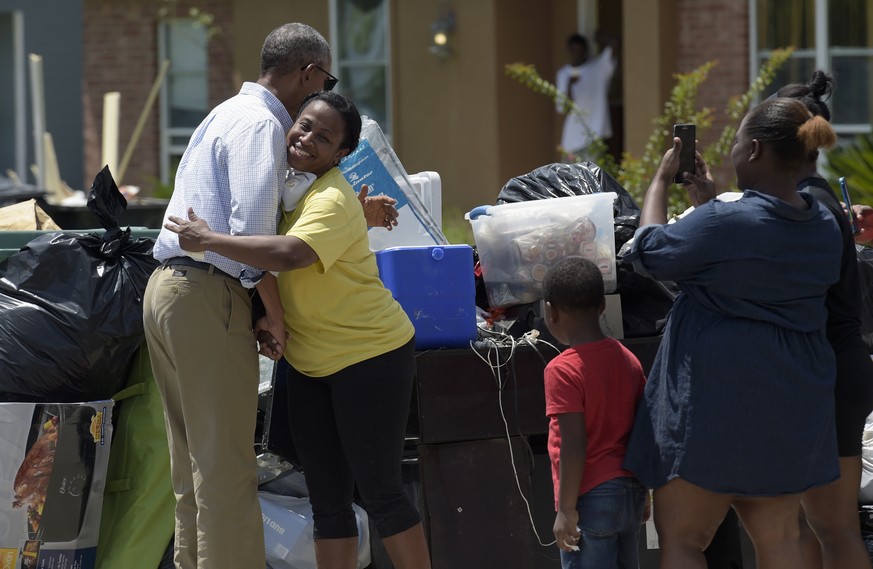 President Barack Obama hugs Marlette Sanders as he tours Castle Place, a flood-damaged area of Baton Rouge, La., Tuesday, Aug. 23, 2016. Obama is making his first visit to flood-ravaged southern Louis ...